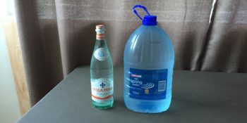 Plastikwasser und in der Glasflasche